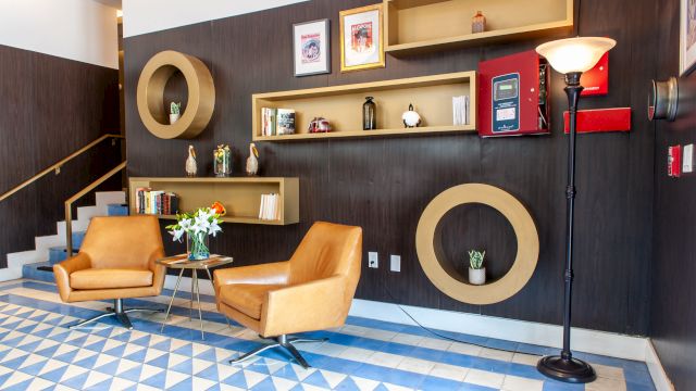 A lobby lounge with two leather chairs, a coffee table, and a floor lamp.